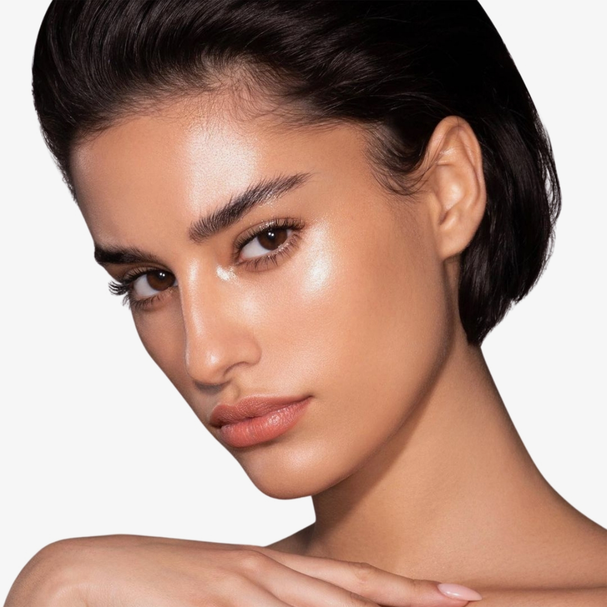 Frau mit strahlender Haut und kurzen dunklen Haaren präsentiert Danessa Myricks Beauty Balm Contour vor einem schlichten Hintergrund.