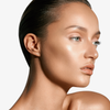 Eine Frau mit glatter, strahlender Haut trägt Danessa Myricks Beauty Balm Contour, ihr Haar ist nach hinten gegelt und steht vor einem weißen Hintergrund.