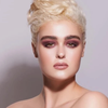Platinblonde Frau mit kräftigen Brauen und dramatischen burgunderroten Augen trägt Danessa Myricks Beauty Balm Contour.