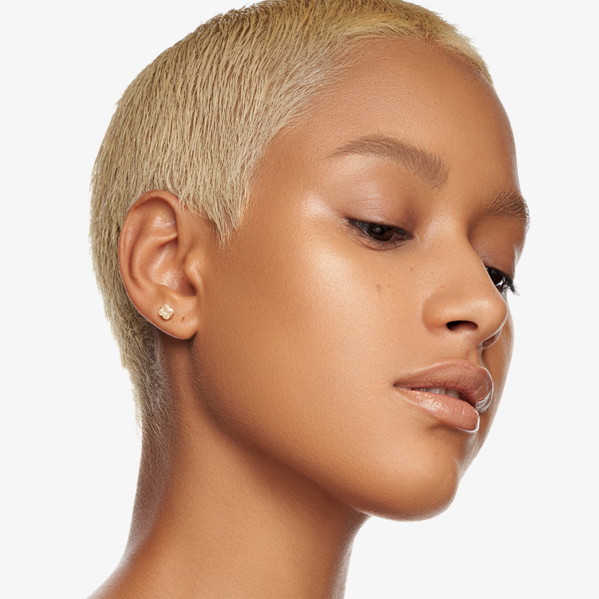 Eine Frau mit kurzen blonden Haaren und strahlender Haut präsentiert Danessa Myricks Beauty Balm Contour vor einem weißen Hintergrund.