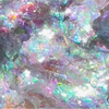 Die Infinite Chrome Flakes Pixie Dust von Danessa Myricks Beauty zeichnen sich durch eine schillernde, farbenfrohe, abstrakte Textur mit blauen, lila und grünen Tönen sowie einem Hauch von Weiß aus.