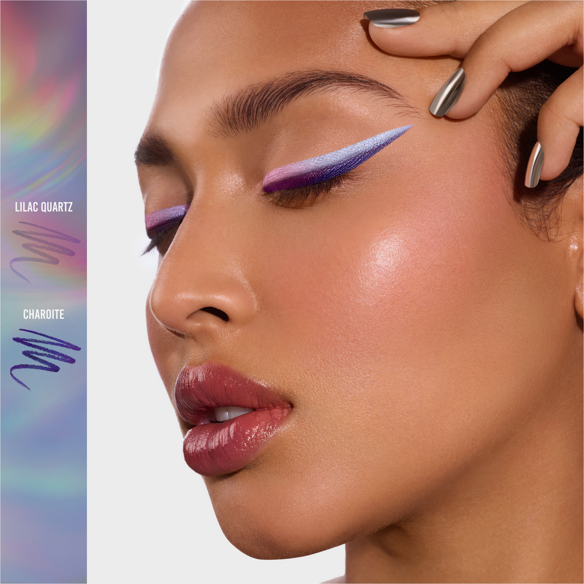 Eine Frau trägt einen auffälligen lilafarbenen und weißen geflügelten Eyeliner, der mit Danessa Myricks Beauty Infinite Chrome Pencil aufgetragen wurde, kombiniert mit glänzenden Lippen und metallischen Nägeln. Farbmuster sind auf der linken Seite zu sehen.
