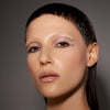 Eine Frau mit hellem Teint zeigt Make-up-Look mit lilafarbenem Infinite Chrome Pencil.