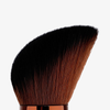 Nahaufnahme von Danessa Myricks Beauty Yummy Face 1.0 All Over Complexion Brush mit braunen Borsten, auf weißem Hintergrund.