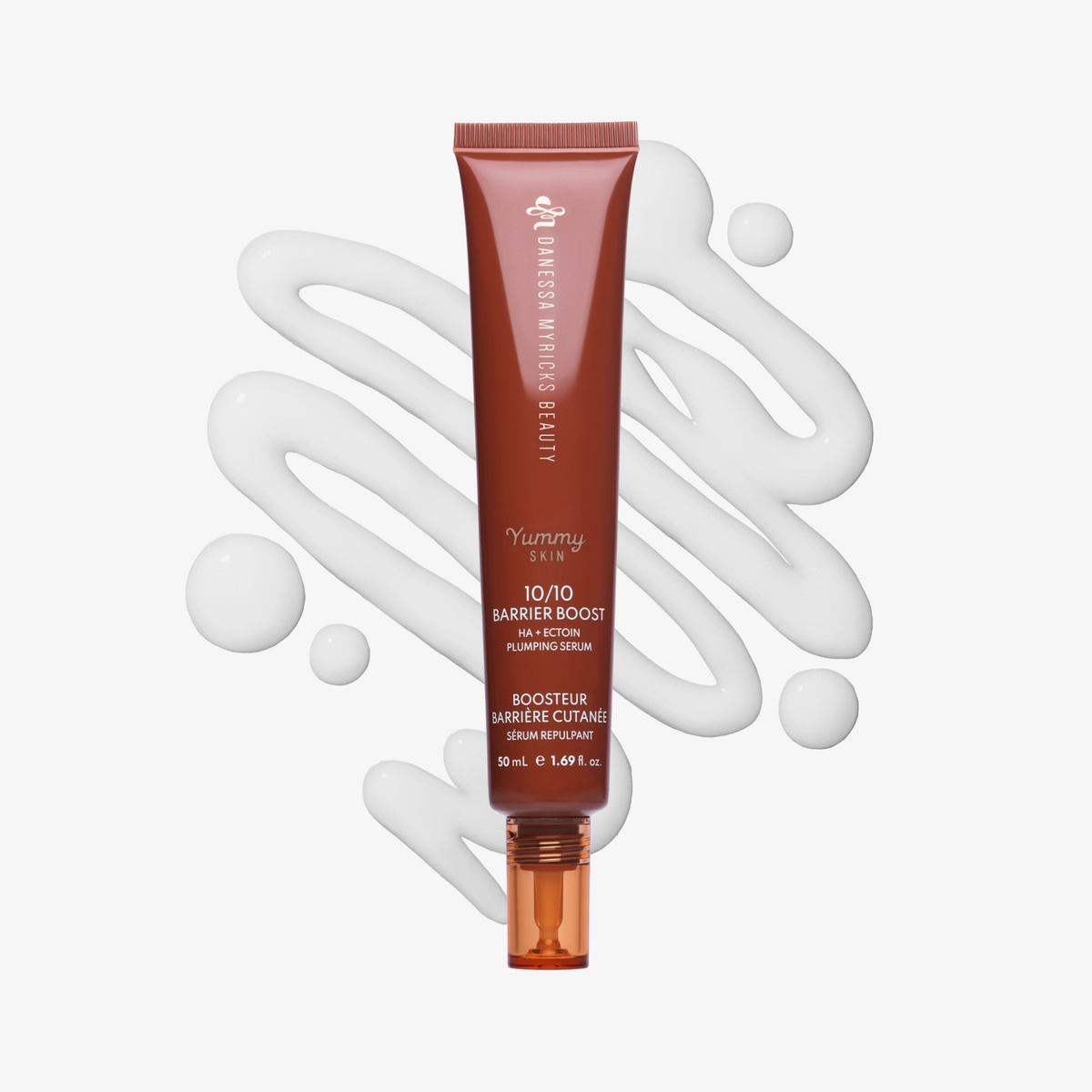 Eine Tube des Serums Danessa Myricks Beauty Yummy Skin 10/10 Barrier Boost ist mit dem Serum im Hintergrund auf einer weißen Fläche abgebildet.