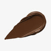 Ein tiefbrauner Farbstreifen Yummy Skin Lift & Flex Concealer 16 auf weißem Hintergrund.