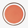 Runde geöffnete Dose Yummy Skin Blurring Balm Powder Lowlighter Lowkey in warmem Korall auf weißem Hintergrund.