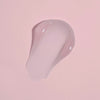 Das klare Gel des Moisture Grip Serum Primer erscheint als Tropfen auf einem hellrosa Hintergrund.