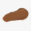 Ein sanfter Strich Silktone Cream Bronzer in Mittelbraun auf weißem Hintergrund.