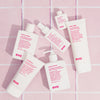 Mehrere Produkte von Evo auf rosa Fliesen, darunter der Easy Tiger Smoothing Balm.