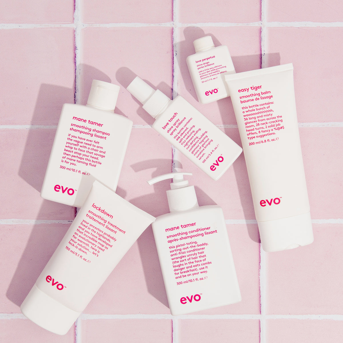 Mehrere Produkte von Evo auf rosa Fliesen, darunter der Easy Tiger Smoothing Balm.