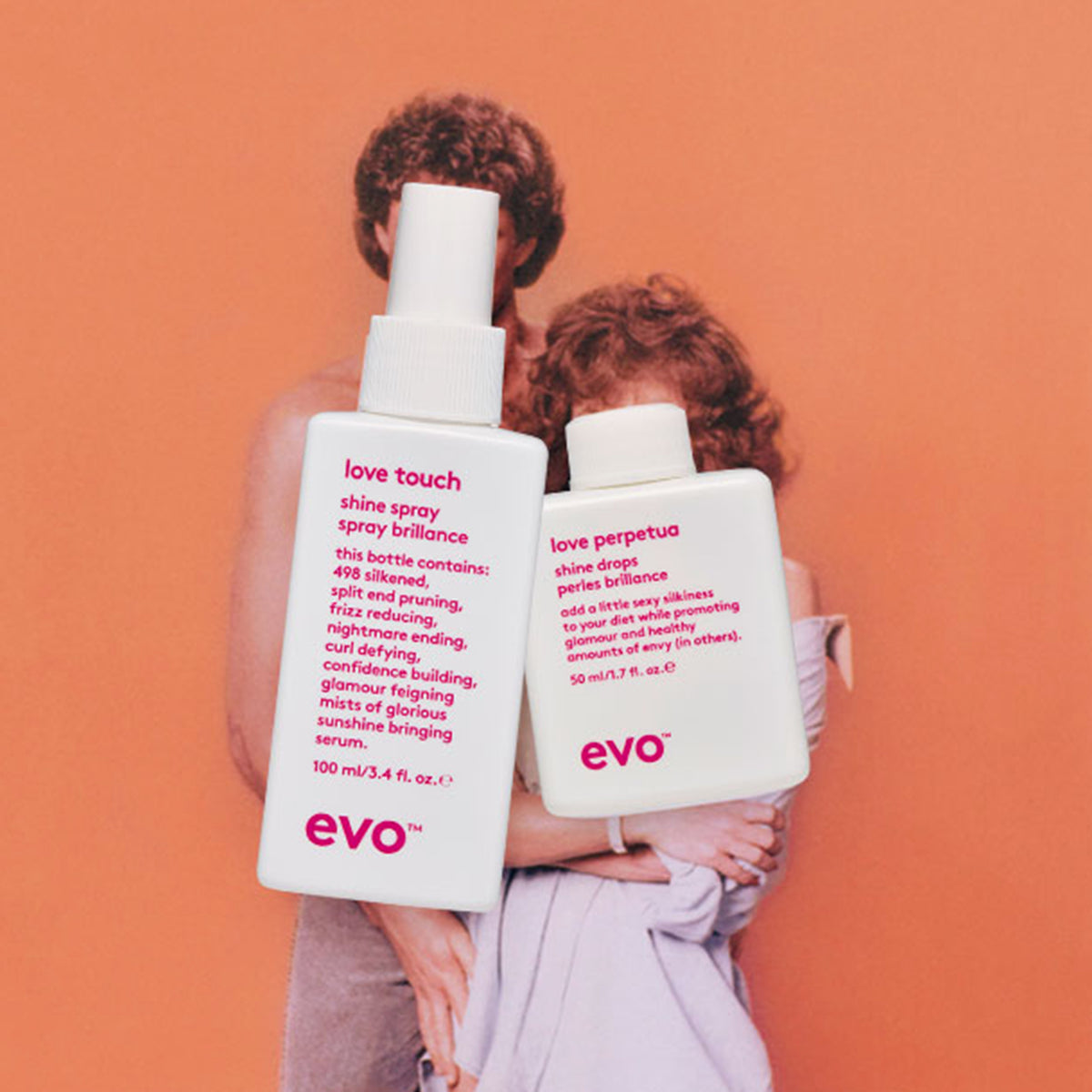 Evo Love Touch Shine Spray  und Love Perpetua Shine Drops vor einem orangen Vintage-Foto eines sich umarmenden Paares.