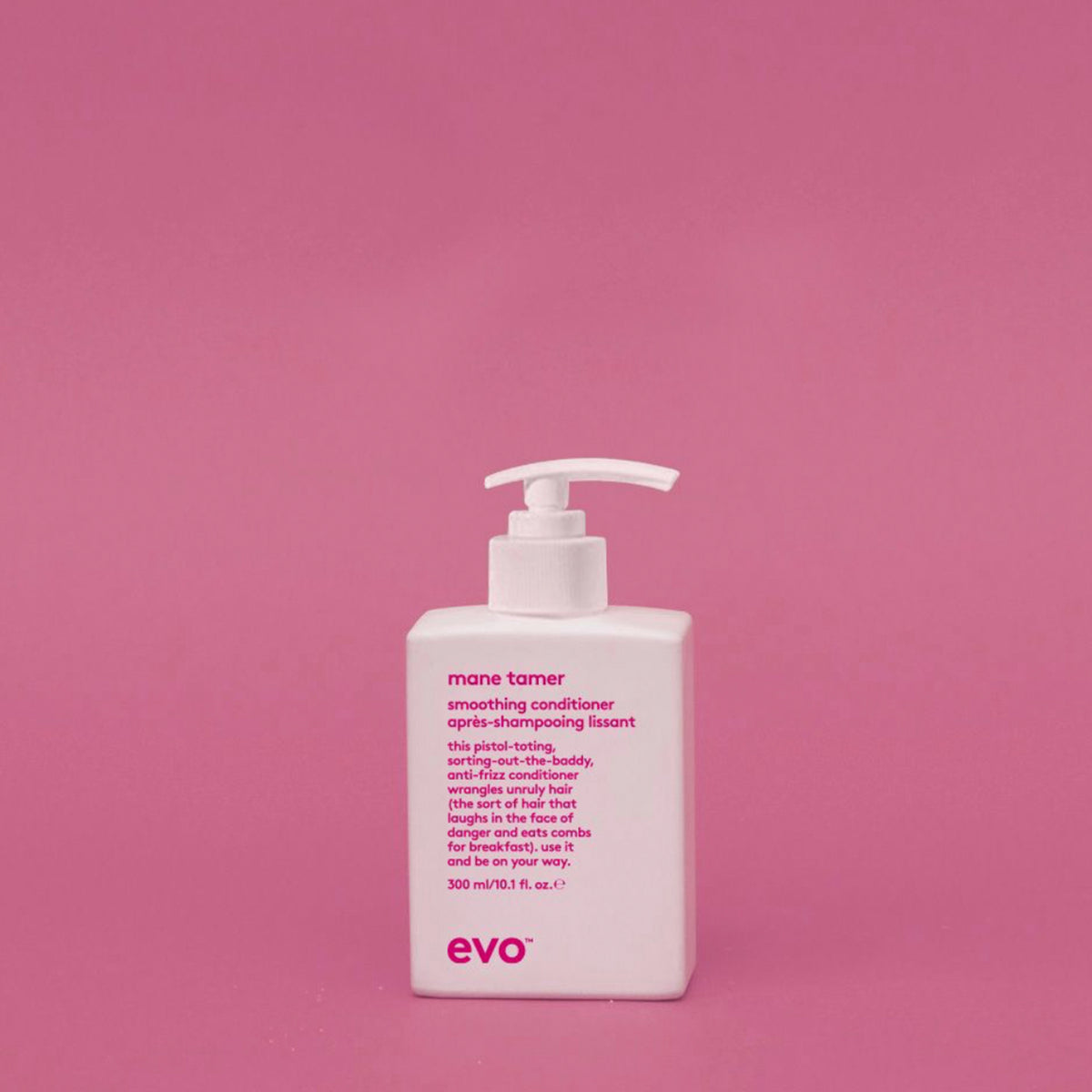 Eine weiße Pumpflasche Mane Tamer Smoothing Conditioner steht vor einem einfarbig rosa Hintergrund.