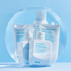Mehrere Produkte von Evo in einem Goldfischglas mit sprudelndem Wasser vor blauem Hintergrund; darunter das The Therapist Hydrating Shampoo.