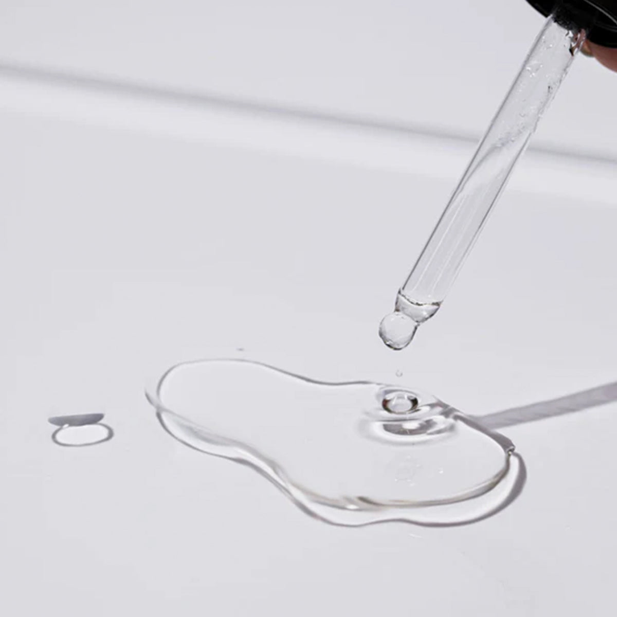 Eine Pipette verteilt Tropfen des PolyPep Collagen Boosting Serum S8 PRO auf einer weiße Oberfläche.