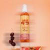 Eine Flasche Haarsirup Rapunzel Haaröl mit Kirschen, Mandeln und einer Grapefruitscheibe daneben.