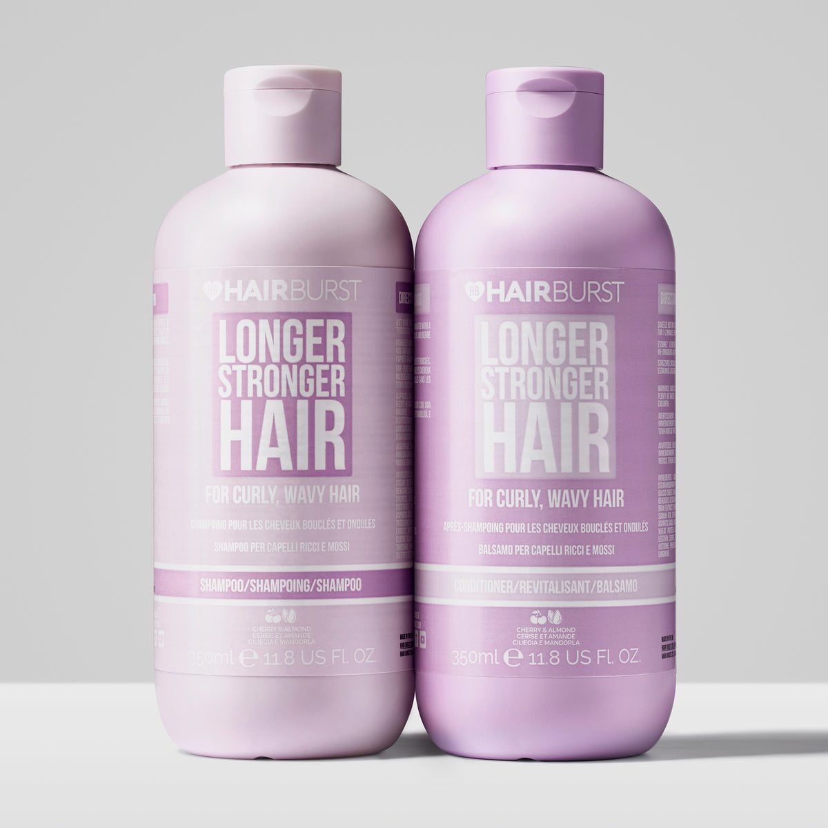 Auf einem schlichten hellen Hintergrund sind zwei violette Flaschen Shampoo und Conditioner aus dem Shampoo & Conditioner for Curly and Wavy Hair dargestellt.