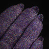 Nahaufnahme von mit Glitter Pot Glass Slipper überzogenen Fingern mit funkelndem lila Glitzer.