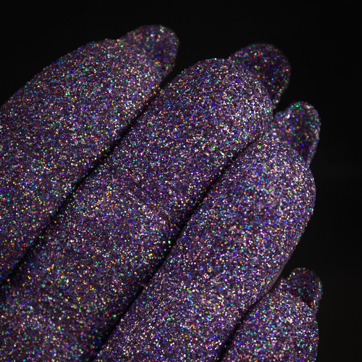 Nahaufnahme von mit Glitter Pot Glass Slipper überzogenen Fingern mit funkelndem lila Glitzer.