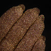 Nahaufnahme von mit Glitter Pot Golden Rose überzogenen Fingern mit funkelndem gold-rosa Glitzer.