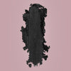 Ein schwarzer Klecks Moonshadow Matte Pressed Eyeshadow mit Glitzer auf rosa Hintergrund.