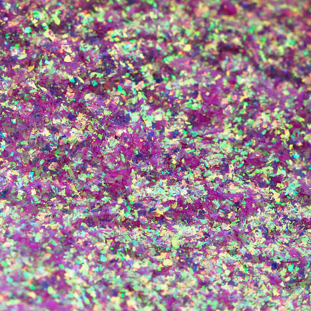 Nahaufnahme der Textur des des Opal Moonstone Loose Multichrome Eyeshadow Boujee Bae; ein grün-rosa schimmerndes Pigment.