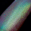 Nahaufnahme einer Fingerspitze, die in den Opal Multichrome Loose Eyeshadow Sweetdreams getaucht wurde und gelb-grün-türkis glitzert.