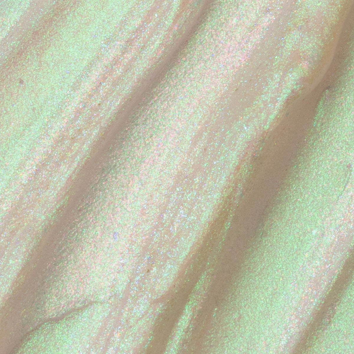 Nahaufnahme der Textur des Opal Shadow Potion Silky Gel Eyeshadow Chill; eine opal-grünlich schimmernde Pigmentcreme.