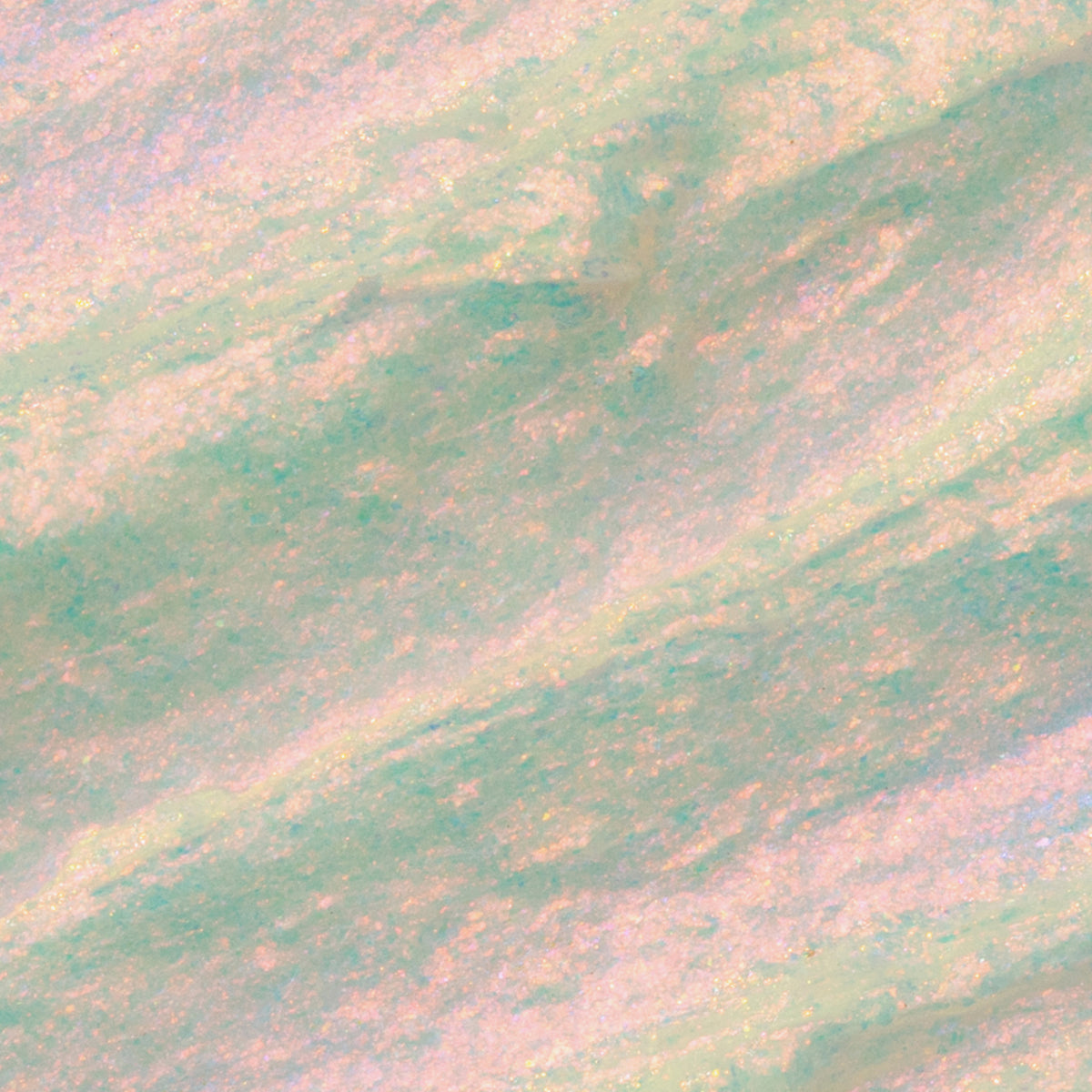 Nahaufnahme der Textur des Opal Shadow Potion Silky Gel Eyeshadow Pillow Fight; eine grün-rosa schimmernde Pigmentcreme.