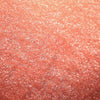 Nahaufnahme der Textur des Pastel Duochromes Loose Eyeshadow Pigtails; ein pfirsichfarbenes schimmerndes Pigment.