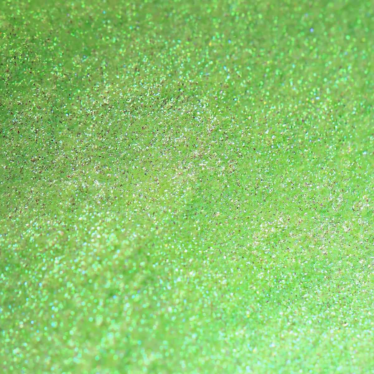 Nahaufnahme der Textur des Pastel Duochromes Loose Eyeshadow Pom Pom; ein neongrün schimmerndes Pigment.