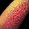 Nahaufnahme einer Fingerspitze, die in den Pastel Duochromes Loose Eyeshadow Sherbet getaucht wurde und gelb und orange glitzert.