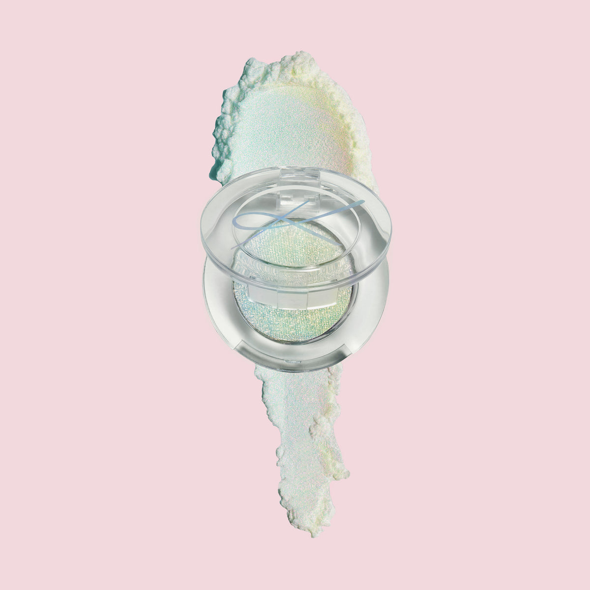 Kompaktdose des Pressed Opal Multichrome Eyeshadow Beauty Sleep auf einem opal-schimmerndem Farbmuster auf blassrosa Hintergrund.