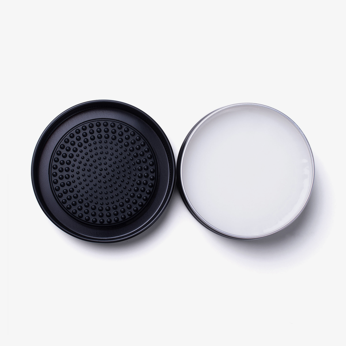 Eine geöffnete Dose Lethal Cosmetics Brush Soap mit einem schwarzen, strukturierten Deckel daneben, von oben gesehen auf weißem Hintergrund.