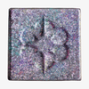 Quadratisches Pfännchen des MAGNETIC™ Pressed Multichrome Shadow "Moonstone" von Lethal Cosmetics in glitzerndem lila-blaugrün mit floraler Prägung in der Mitte.
