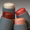 Vier LH Cosmetics Artistick Highlighter - graue Tuben mit weißem, rotem, rosa und pfirsichfarbenem Schimmer.