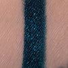Blaugrün glitzerndes Muster des Crayon Atria von LH Cosmetics auf heller Haut.