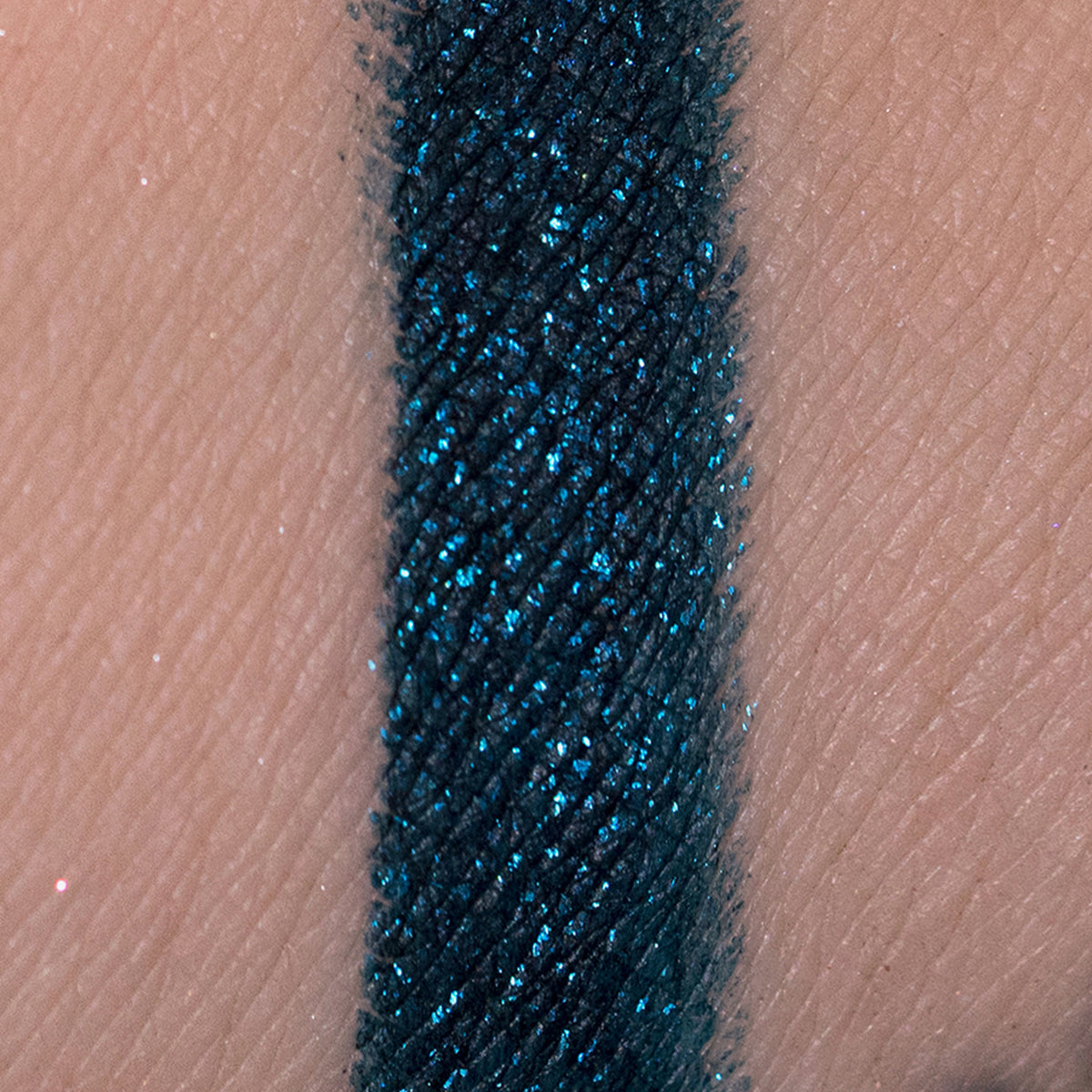 Blaugrün glitzerndes Muster des Crayon Atria von LH Cosmetics auf heller Haut.