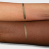 Zwei Unterarme mit je einem grün-glänzenden Crayon Gemma Swatch, um die Farbwiedergabe auf heller und dunkler Haut zu zeigen.