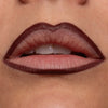 Dunkel umrandete Lippen mit natürlicher Lippenfarbe in der Mitte, Nahaufnahme eines teilweise geöffneten Mundes.