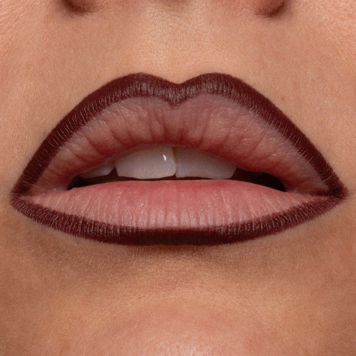 Dunkel umrandete Lippen mit natürlicher Lippenfarbe in der Mitte, Nahaufnahme eines teilweise geöffneten Mundes.