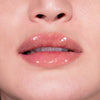 Nahaufnahme von Lippen einer Person mit hellem Teint mit leicht orange glitzerndem Glazed Melt Lipgloss von LH Cosemtics.