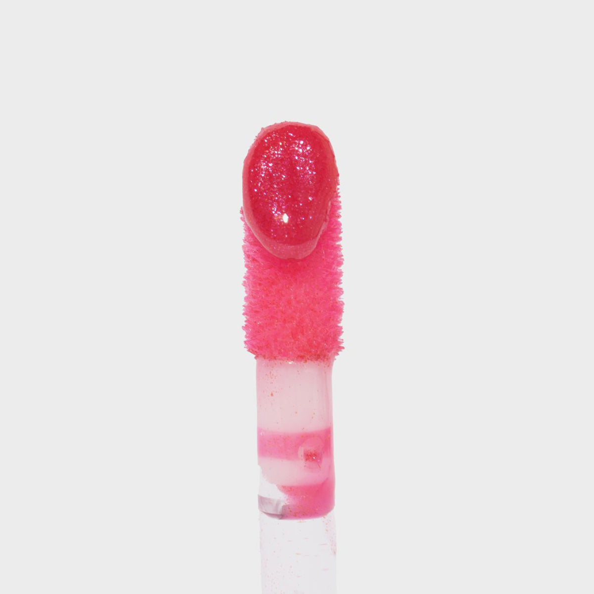 Nahaufnahme des Glazed Sugar Applikators von LH Cosmetics mit pink glitzerndem Lipgloss auf weißem Hintergrund.