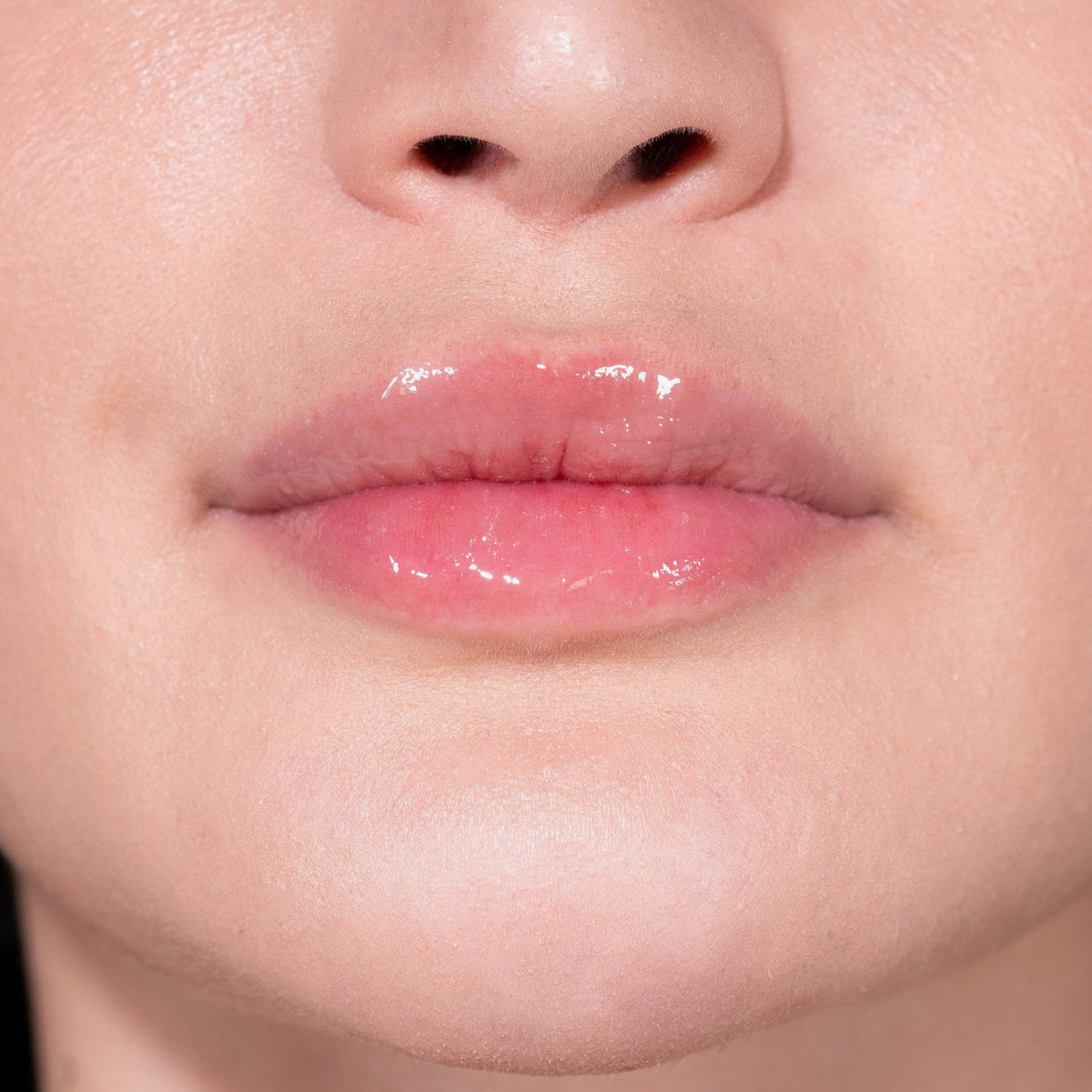 Nahaufnahme von Lippen einer Person mit hellem Teint mit transparentem Glazed Sweet Lipgloss von LH Cosmetics.