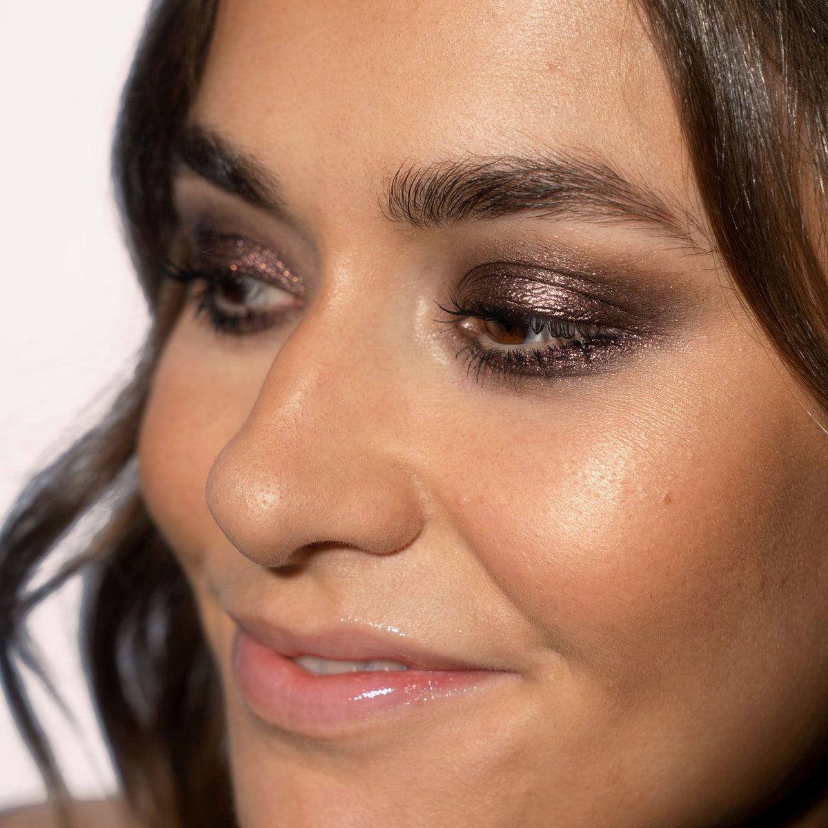 Nahaufnahme des Gesichts einer Frau mit braun-bronze glitzerndem Lidschatten Sparkl Glitz von LH Cosmetics.