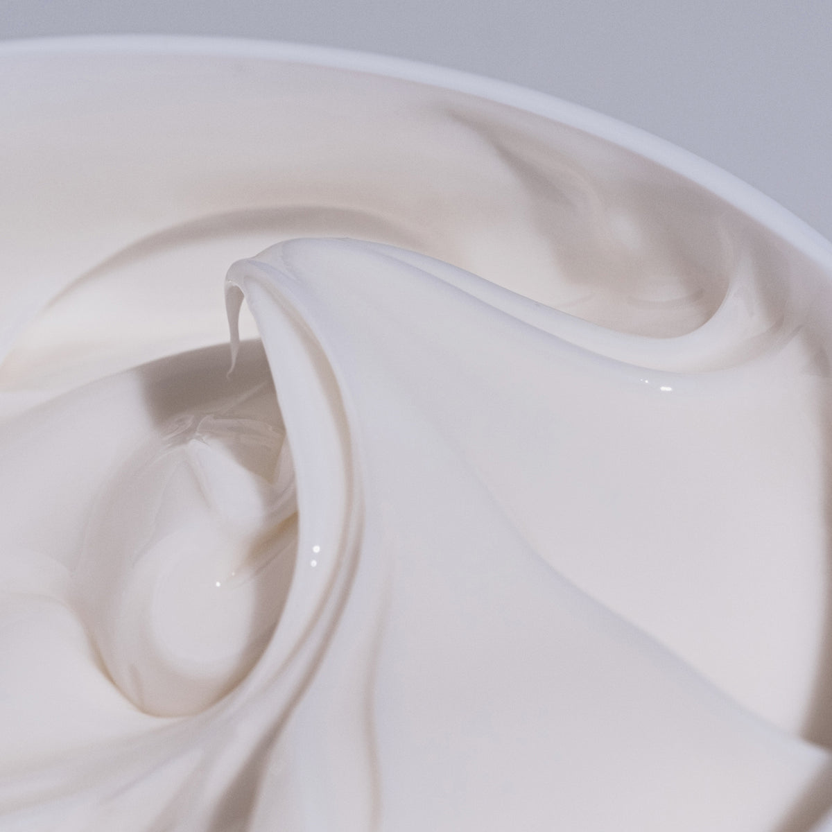 Nahaufnahme der weißen Geltextur von Living Proof Curl Elongator in einem Behälter.