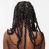 Eine Person mit langen Braids von hinten vor einem weißen Hintergrund, präsentiert Living Proof Scalp Care Dry Scalp Treatment.