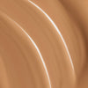 Nahaufnahme der warmbraunen cremigen Textur der Lumene Invisible Illumination Serum in Foundation SPF30 in der Farbe 7.