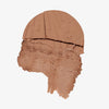 Ein gebrochener NATURAL GLOW Bronzer von Lumene in Arcitic Sun (warmes Braun), der eine strukturierte Puderoberfläche aufweist.