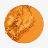 Hergestellt von Mitchell Blursh Press'd: zerkleinertes orangefarbenes Make-up-Pulver in einer runden Schale auf weißem Hintergrund.